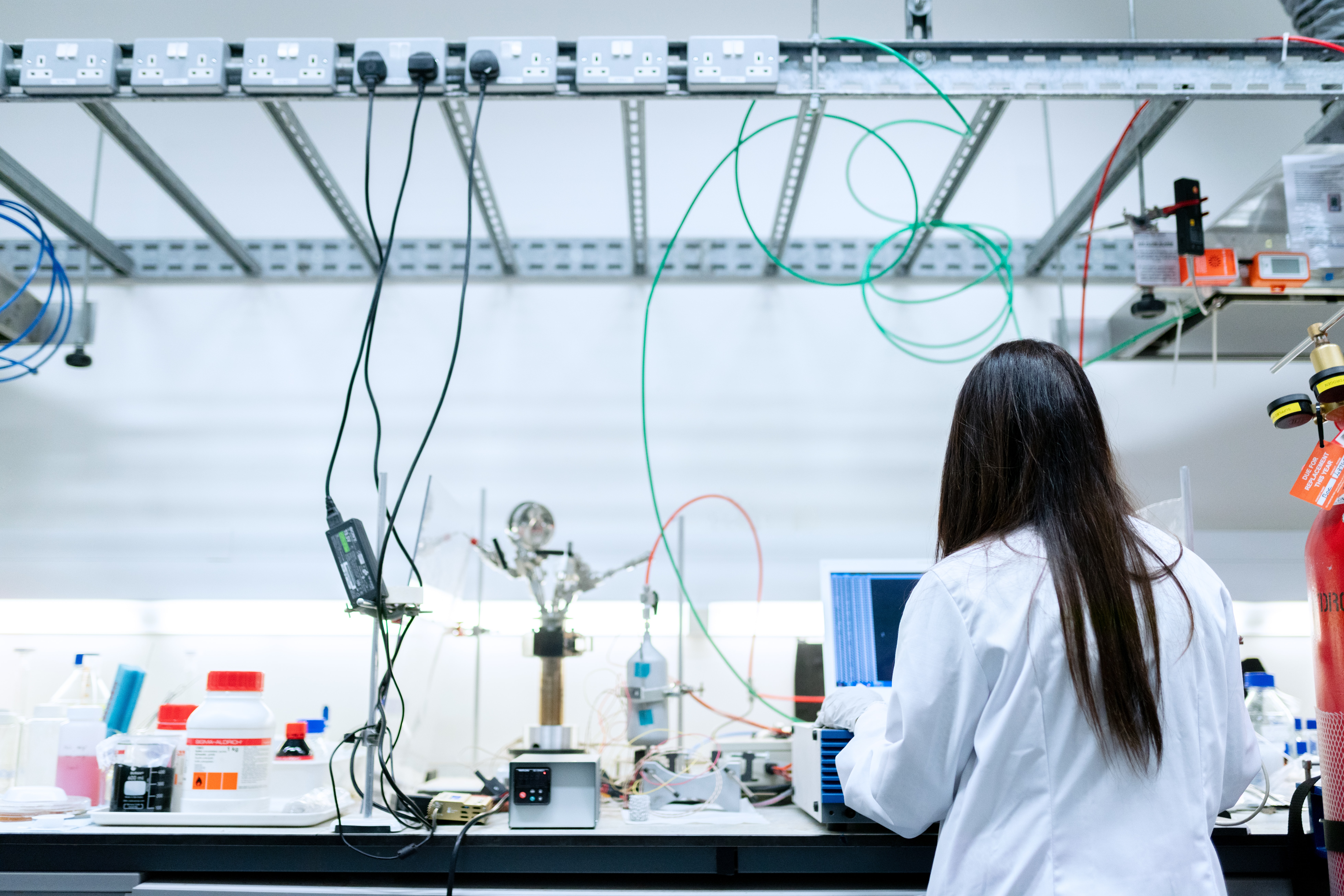 Engineer working at a lab bench with instrumentation and cabling